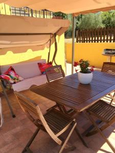 Una mesa y sillas bajo una sombrilla en un patio. en La Rosa del lago, en Bracciano