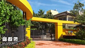 un edificio amarillo con una puerta negra y una valla en Anapoima Natura, en Anapoima
