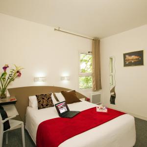 une chambre d'hôtel avec un lit et une couverture rouge dans l'établissement Hotel Cerise Nancy, à Nancy