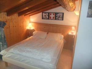 1 dormitorio con 1 cama blanca y 2 lámparas en Chalet les Gentianes, en Les Coches