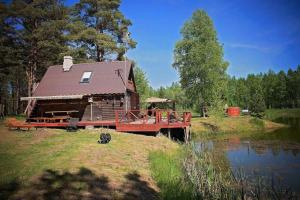 ein Blockhaus mit einer Brücke neben einem See in der Unterkunft Rehe Holiday Home in Rootsiküla