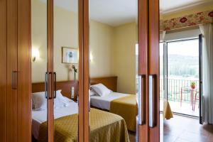 a hotel room with two beds and a balcony at Balneario de Fitero - Hotel Bécquer in Fitero +44 photos