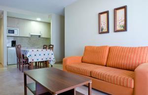 salon z kanapą i stołem w obiekcie Sanxenxorural - Apartamentos La Rana w mieście Sanxenxo