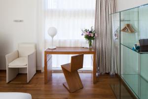 een bureau met een vaas met bloemen en een stoel bij Hôtel La Pérouse in Nantes +36 foto's