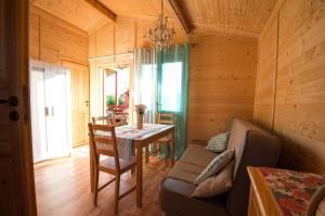a dining room with a table and a couch at Domki letniskowe Nadia in Grzybowo