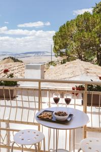 una mesa con dos copas de vino y un plato de comida en Miramonte Holiday, en Montescaglioso