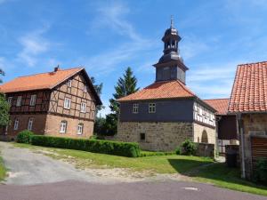 Un vieux bâtiment avec une tour d'horloge en haut dans l'établissement Hotel Gasthaus Weisser Mönch, à Blankenburg