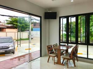 a dining room with a table and a view of a car at Dusita Residence ดุสิตา เรสซิเดนซ์ in Phetchabun