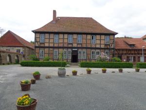 un grand bâtiment avec des plantes en pot devant lui dans l'établissement Hotel Gasthaus Weisser Mönch, à Blankenburg