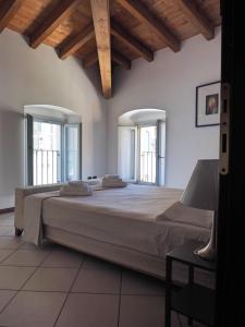 een slaapkamer met een groot bed en 2 ramen bij Appartamenti al Golfo in Salò