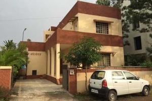 a white car parked in front of a building at MTDC Approved Mohiniraj Guest House in Nashik