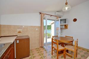 a kitchen and dining room with a table and chairs at Apartments Vila Punta in Jadrtovac