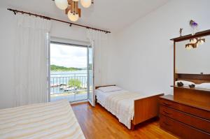 a bedroom with two beds and a window with a balcony at Apartments Vila Punta in Jadrtovac