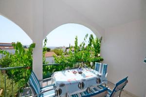 a table and chairs on a balcony with a view at Apartment Pavica in Rogoznica