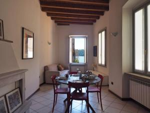 a dining room with a table and chairs and a fireplace at Appartamenti al Golfo in Salò