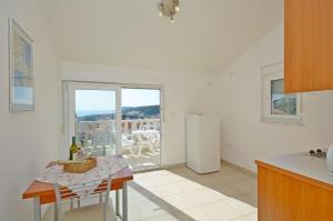 a kitchen with a table and a refrigerator at Apartments Marija in Hvar