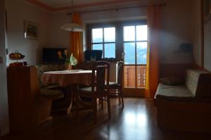 een woonkamer met een tafel en stoelen en een raam bij Fesengut in Annaberg im Lammertal