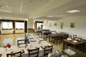 a dining room with tables and chairs in a room at Vila Maria Snagov in Snagov
