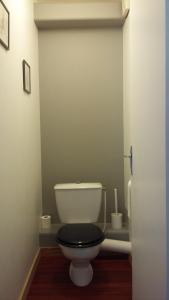 a bathroom with a white toilet with a black seat at La Source in Saint-Amand-Magnazeix