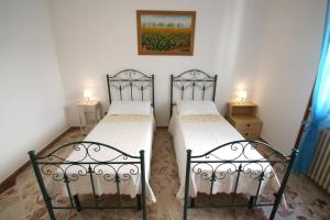 ガリポリにあるAppartamento bouganvilleのランプ2つが備わる客室で、ツインベッド2台が付いています。