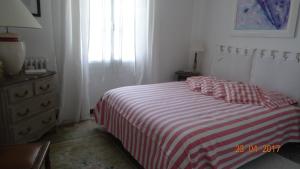 a bedroom with a bed with a red and white striped blanket at La maisonnette in Crillon-le-Brave