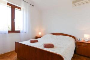 Schlafzimmer mit einem Bett mit weißer Bettwäsche und einem Fenster in der Unterkunft Apartments Pero in Zapuntelo