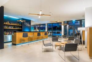 a restaurant with chairs and tables and a bar at Vila Baleira Village in Porto Santo
