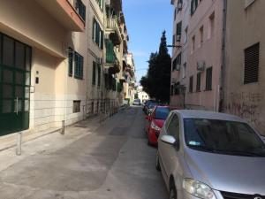 two cars parked on a street next to buildings at Apartment Andelina in Split