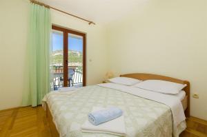 sypialnia z dużym łóżkiem i oknem w obiekcie Apartments Toni w Primošten