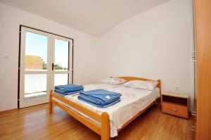 sypialnia z łóżkiem z niebieskimi ręcznikami w obiekcie Apartments Renato w Novalji