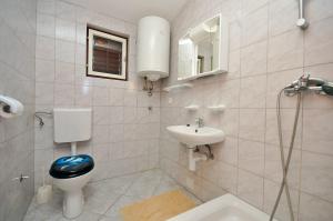 łazienka z toaletą i umywalką w obiekcie Apartments Renato w Novalji