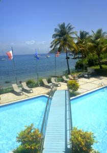 a swimming pool with a view of the ocean at Hôtel Bois Joli in Terre-de-Haut
