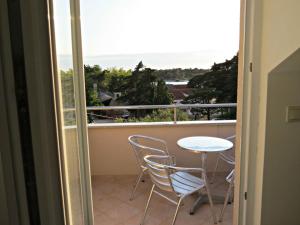 a balcony with a table and chairs and a view of the ocean at Apartments Karolina in Novalja