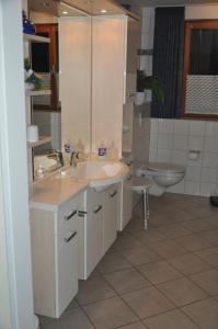a bathroom with two sinks and a toilet at Haus Waldblick in Hagen