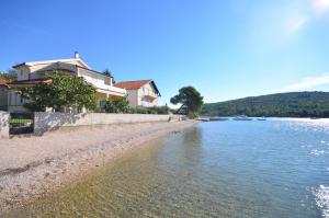 a house on the shore of a body of water at Apartments Rosanda in Pirovac