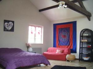 een slaapkamer met een paars bed en een rode stoel bij Les Lutins in Sainte-Ruffine