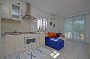 a kitchen and living room with a blue couch at Apartments Danica in Vodice