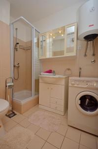 uma casa de banho com uma máquina de lavar roupa e um chuveiro em Apartments Danica em Vodice