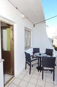 een patio met stoelen, een tafel en een raam bij Apartments Zeljko in Pag