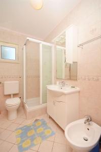 uma casa de banho com um lavatório, um WC e um chuveiro em Apartments Branislav em Rogoznica
