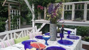 una mesa con platos de comida y un jarrón con flores en Lovely Mint Garden Studio, en Vantaa