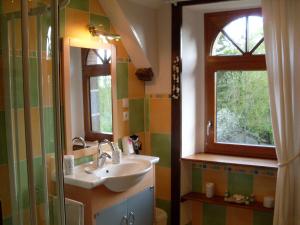 uma casa de banho com um lavatório e uma janela em Chambres d'Hôtes de la Barrerie em Dingé