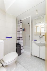 a white bathroom with a toilet and a sink at Apartment Antonio in Bogomolje
