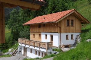 a house with a wooden roof on a hill at Lechtaler Naturparkchalets in Gramais