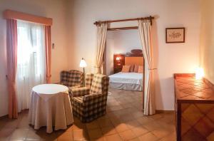 Habitación de hotel con cama, mesa y sillas en Hotel Rural Son Tretze - Adults Only en Sant Lluís