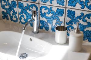 um lavatório de casa de banho com uma torneira com água a sair em Cortile Umberto I em Cefalù