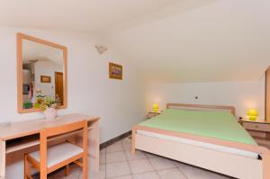 - une chambre avec un lit, un bureau et un miroir dans l'établissement Apartments Milan, à Medveja
