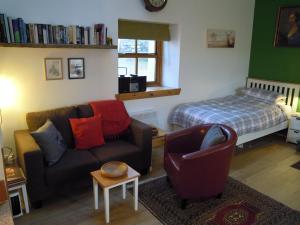 a living room with a couch and a bed at The Smithy House & Cottages in Lochinver
