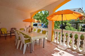 a dining room with a table and an umbrella at Apartments Finka in Vodice