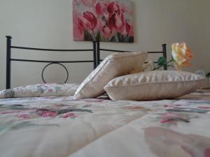 un letto con due cuscini sopra di Affittacamere La Camelia a Lucca